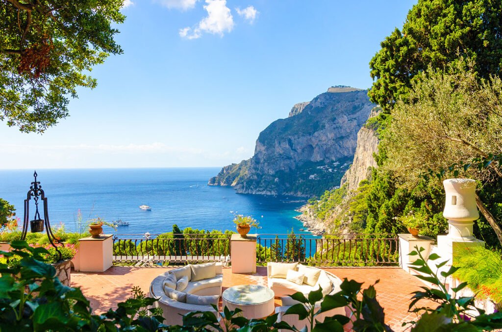 Exclusive luxury tours and events in Italy with Amalfi Coast terrace view of Mediterranean Sea and cliffs by Chaya Voyages.