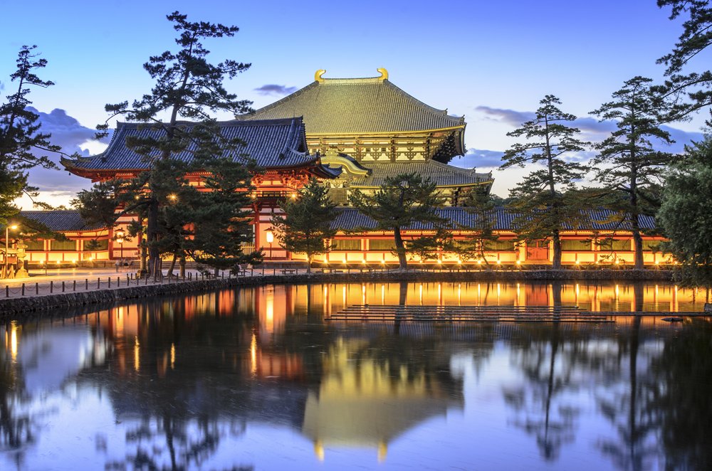 Exclusive luxury tours and events in Japan featuring Todai‑ji Temple illuminated at twilight with serene water reflections by Chaya Voyages.